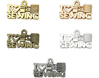 Puede incluir: Cuatro abalorios con las palabras "Me encanta coser" y un diseño de máquina de coser. Los abalorios están disponibles en acabados dorado, plateado y dorado antiguo.