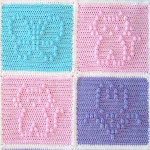 May include: Four crocheted squares in different colors: light blue, pink, pink, and purple. Each square has a raised heart design.