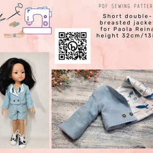 May include: A PDF sewing pattern for a short double-breasted jacket for a 13-inch Paola Reina doll. The jacket is blue with a white and blue fish print lining. The pattern includes a QR code.