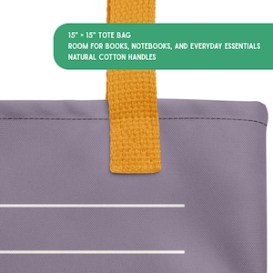 May include: A purple tote bag with a mustard yellow handle. The bag features two horizontal white lines and a green text box stating: 15" x 15" TOTE BAG, ROOM FOR BOOKS, NOTEBOOKS, AND EVERYDAY ESSENTIALS, NATURAL COTTON HANDLES.