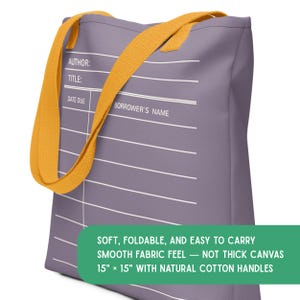 May include: A purple tote bag featuring a white library checkout card graphic with the text AUTHOR, TITLE, DATE DUE, and BORROWER'S NAME. The bag has yellow handles and a green rectangular label stating it is 15 inches by 15 inches.