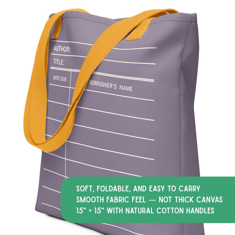 May include: A purple tote bag featuring a white library checkout card graphic with the text AUTHOR, TITLE, DATE DUE, and BORROWER'S NAME. The bag has yellow handles and a green rectangular label stating it is 15 inches by 15 inches.