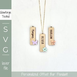 May include: A personalized offset bar pendant necklace with three wooden rectangular charms. Each charm has a name engraved on it, with decorative butterfly, flower, and bow accents. The necklace is on a white background.