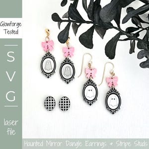 Puede incluir: Un conjunto de pendientes con temática de Halloween. Los pendientes presentan un diseño de fantasma dentro de un marco ovalado, acentuado con lazos rosas. También se incluyen pendientes de botón con un patrón de cuadros blancos y negros. El texto "Haunted Mirror Dangle Earrings + Stripe Studs" es visible.