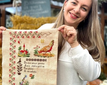 May include: A beige cross-stitch embroidery with a red roofed house, a bird, and a verse in French. The verse reads "De mon amour prenez Amie chéris,qu'il es que pleins A vos enfants". The embroidery is signed "Céline Louvenas".