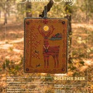 May include: A framed, hand-stitched textile art piece featuring a deer design. The artwork, titled "Solstice Deer," showcases a deer with a red and brown striped body, adorned with embellishments and intricate stitching. The finished size is approximately 4.8 x 6.3 inches.