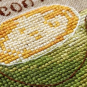 Puede incluir: Primer plano de un dise&ntilde;o de punto de cruz de una taza de caf&eacute; con el texto "Tea or Coffee" arriba.