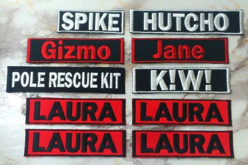 May include: A collection of eight embroidered patches with various names and phrases, including "Spike", "Gizmo", "Hutcho", "Jane", "Pole Rescue Kit", "K!W!" and "Laura". The patches are black with white or red lettering.