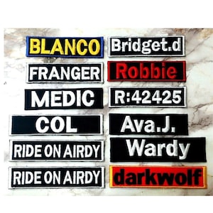 May include: Ten embroidered patches with various names and phrases, including "BLANCO", "Bridget.d", "FRANGER", "Robbie", "MEDIC", "R:42425", "COL", "Ava.J.", "RIDE ON AIRDY", "Wardy", and "darkwolf".