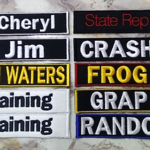 May include: Eight embroidered patches with various text and colors. The patches include the text "Cheryl", "Jim", "BEN WATERS", "Training", "State Rep", "CRASH", "FROG", "GRAP", and "RANDOM".