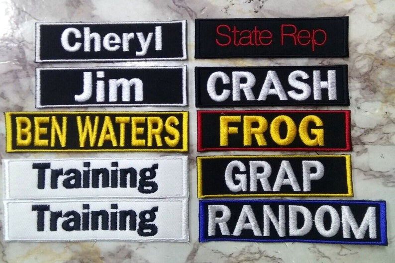May include: Eight embroidered patches with various text and colors. The patches include the text "Cheryl", "Jim", "BEN WATERS", "Training", "State Rep", "CRASH", "FROG", "GRAP", and "RANDOM".