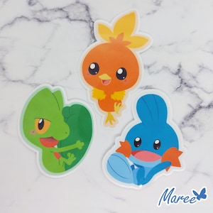 May include: Three cartoon character stickers featuring a green lizard, a blue fish, and an orange bird. The stickers are on a white marble background.