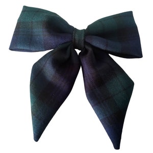 May include: A large green, black, and blue plaid bow with pointed ends.