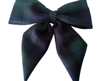 May include: A large green, black, and blue plaid bow with pointed ends.