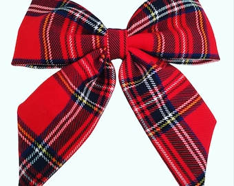 May include: A large red plaid bow with black, white, and yellow accents. The bow is made of a soft, textured fabric.