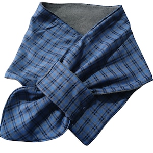 May include: A blue plaid scarf with a grey fleece lining. The scarf is folded and tied in a knot, showcasing the pattern. The plaid design features a combination of blue and black lines.