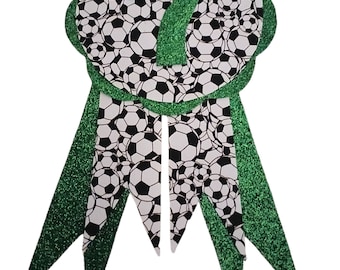 May include: Green and white glitter soccer-themed award ribbon with the number 7 in the center.