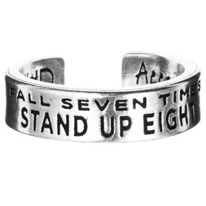May include: Silver toe ring with the inscription "Fall seven times stand up eight".