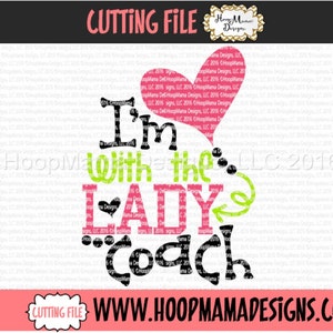 May include: A pink heart with the text "I'm with the LADY Coach" in black and green lettering. The text is in a stylized font.