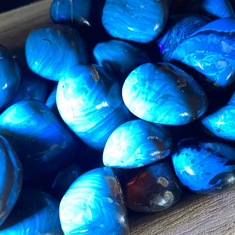 May include: A collection of blue and white tumbled stones with a marbled pattern. The stones are smooth and polished, and they have a variety of shapes and sizes.