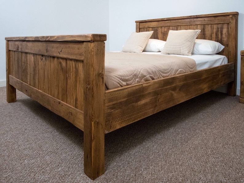 Puede incluir: Un marco de cama de madera r&uacute;stico con un acabado marr&oacute;n natural. La cama tiene una cabecera y un piecero con un dise&ntilde;o de listones. La cama est&aacute; hecha de madera recuperada y tiene un estilo sencillo y de granja.