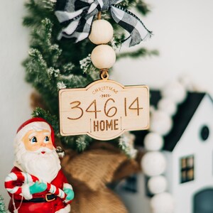 May include: Wooden Christmas ornament with a black and white checkered bow, wooden beads, and the text "Christmas - 2021 - 34614 Home".