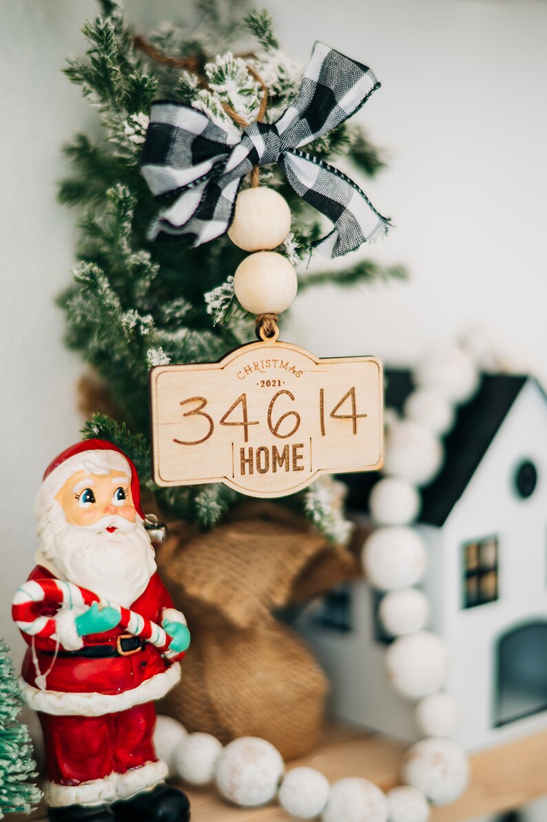 May include: Wooden Christmas ornament with a black and white checkered bow, wooden beads, and the text "Christmas - 2021 - 34614 Home".