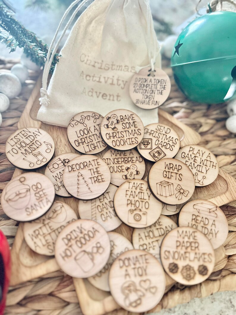 May include: A set of 20 wooden Christmas activity tokens in a white drawstring bag. The tokens feature various Christmas activities such as listening to holiday music, decorating the tree, baking cookies, and wrapping gifts. The tokens are perfect for a Christmas advent calendar or a fun family activity.