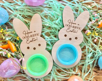 May include: Two wooden bunny-shaped Easter decorations with the text "Have a DOH-RIFFIC Easter!" and a Play-Doh container in the center.