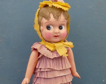 Bambola vintage anni '50 in celluloide, stile flapper girl, con abito originale in carta crespa.