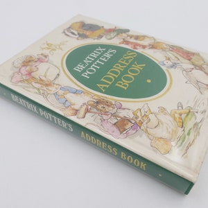 Może przedstawiać: Zielono-biała książka adresowa z tytułem "Beatrix Potter's Address Book" i ilustracjami postaci z książek Beatrix Potter.