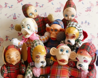 Puede incluir: Un grupo de juguetes de peluche con diferentes formas de animales, todos vestidos con tela de cuadros rojos y negros. Los juguetes incluyen un mono, un perro, un pato, un cerdo y un gato.