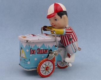 Juguete antiguo de hojalata litografiada de vendedor de helados, de cuerda.