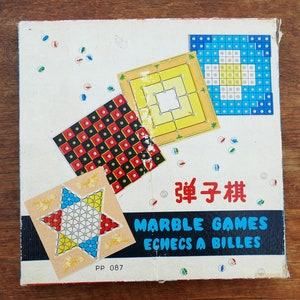 May include: A vintage game box with the text "Marble Games Echecs a Billes" and "弹子棋" in Chinese characters. The box features four different game boards with colorful designs.