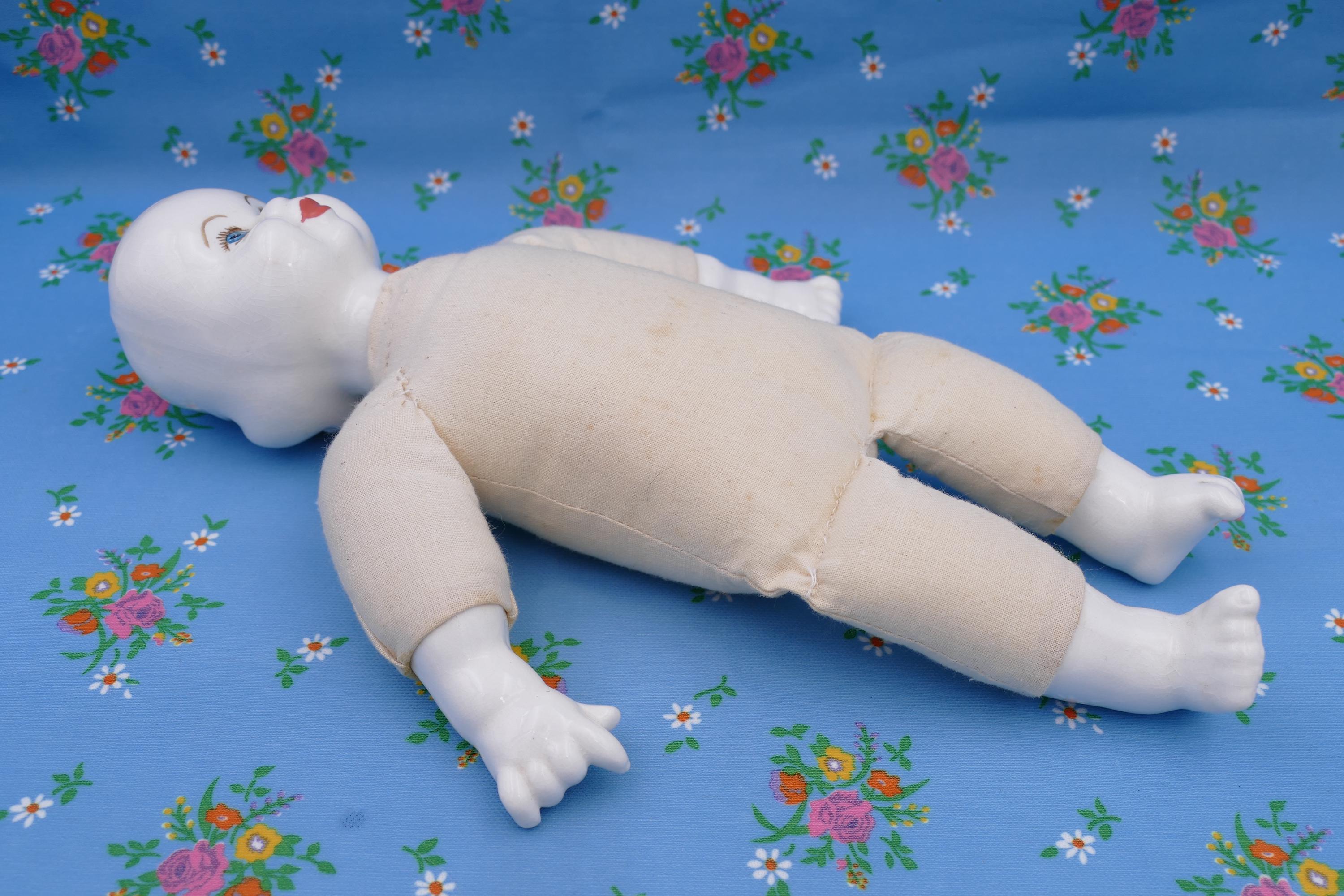 Tête de poupée ancienne en porcelaine avec bras et jambes