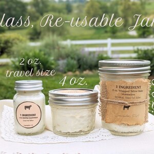 May include: Three glass jars with silver lids containing a white cream. The jars are labeled with a brown paper label that says "1 INGREDIENT 8 oz. Whipped Tallow Balm Moisturizer Grass-fed Tallow". The jars are on a white lace tablecloth. The jars are labeled with the sizes 2 oz., 4 oz., and 8 oz.