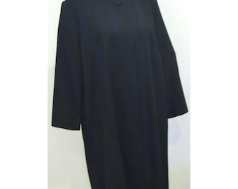 May include: A long, black dress with long sleeves. The dress has a simple, classic design and appears to be made of a smooth fabric. The dress is displayed on a mannequin.