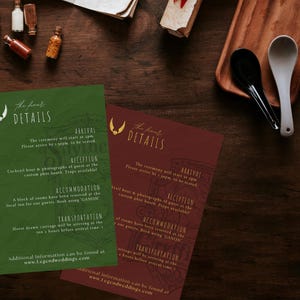 Puede incluir: Dos tarjetas de detalles de boda, una verde y otra burdeos, con texto dorado. Las tarjetas tienen el texto "The finer DETAILS" e incluyen información sobre la ceremonia, la recepción, el alojamiento y el transporte. Las tarjetas están sobre una superficie de madera oscura.