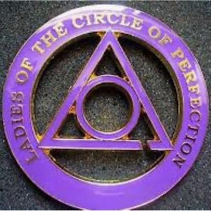 May include: Purple and gold metal pin with the text "Ladies of the Circle of Perfection" around the edge. The center of the pin features a gold triangle with a circle inside.