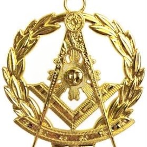 Puede incluir: Pendiente masónico dorado con compás y escuadra, un sol radiante y una corona de hojas.