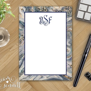 May include: A notepad with a blue and white marbled design and a navy blue border. The notepad has a white space for writing and the monogram "BSF" in navy blue at the top.