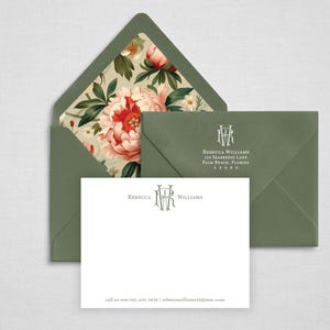May include: A white stationery card and two sage green envelopes. One envelope is open, revealing a floral liner with pink peonies and green leaves. The card and closed envelope feature the monogram RW and the name Rebecca Williams.
