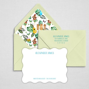 May include: A light green envelope with a tropical patterned liner featuring hula dancers, ukuleles, and tiki statues. A matching scalloped note card displays the name Alexander James and the text Master Mixologist - Tiki Enthusiast in blue.