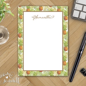 May include: A white notepad with a brown border featuring a pineapple pattern. The notepad has a blank white space for writing and the name "Samantha" is written at the top.