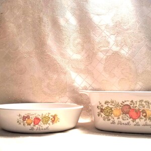 May include: Two white ceramic casserole dishes with a floral design and the text "Le Parfait de la cuisine" and "Le Parfait".