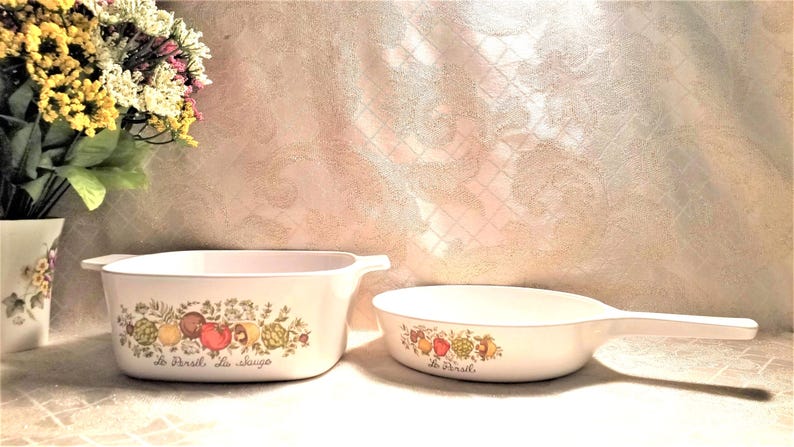 May include: Two white ceramic casserole dishes with floral designs and the text "Le Peril" and "La Sauge".
