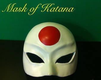 Peut inclure: Masque blanc avec un cercle rouge sur le front et des trous noirs pour les yeux. Le masque est peint et porte les mots "Mask of Katana" au-dessus et "Painted" en dessous.