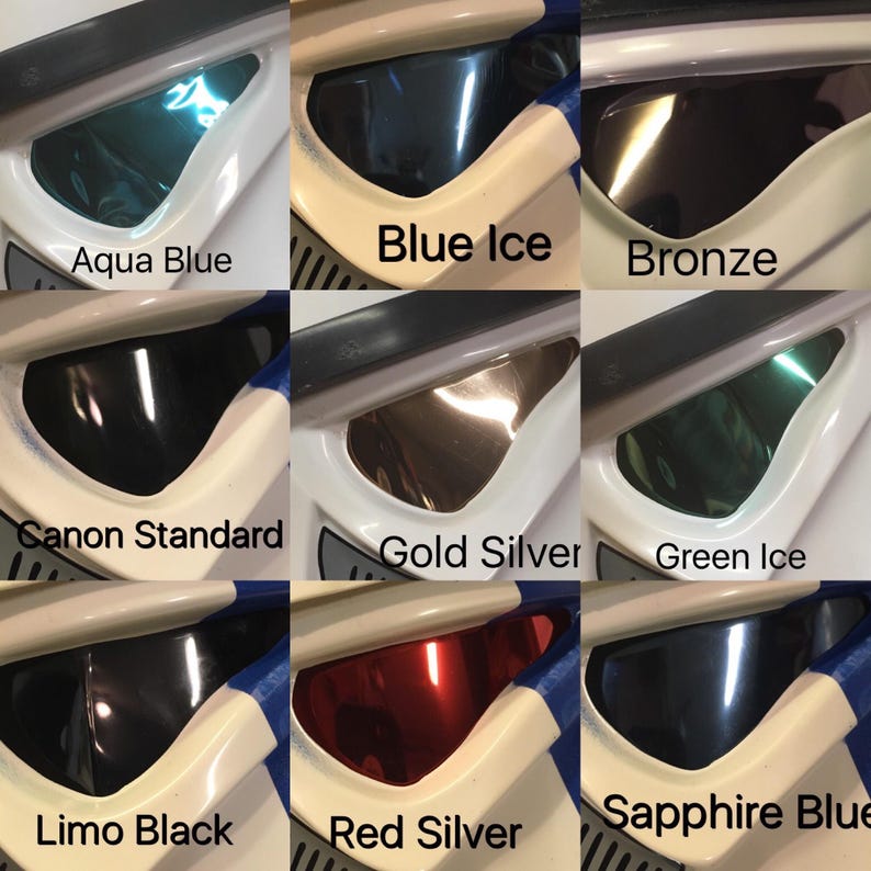 Puede incluir: Primer plano de un casco blanco y azul con varios colores de visera. Los colores de la visera incluyen Aqua Blue, Blue Ice, Bronze, Canon Standard, Gold Silver, Green Ice, Limo Black, Red Silver y Sapphire Blue.