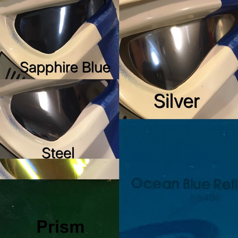 May include: Close-up of four different colored paint samples. The colors are sapphire blue, silver, steel, and ocean blue reflective. The paint samples are on a white surface.