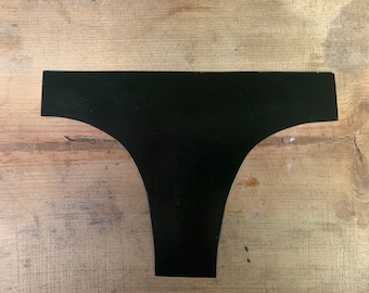 Peut inclure: Découpe de tissu noir en forme de sous-vêtements.